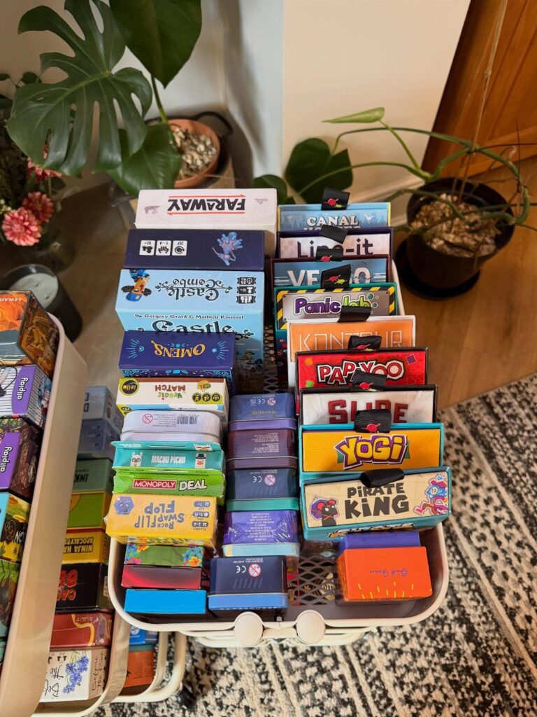 White basket filled with various colorful board game and card game boxes.