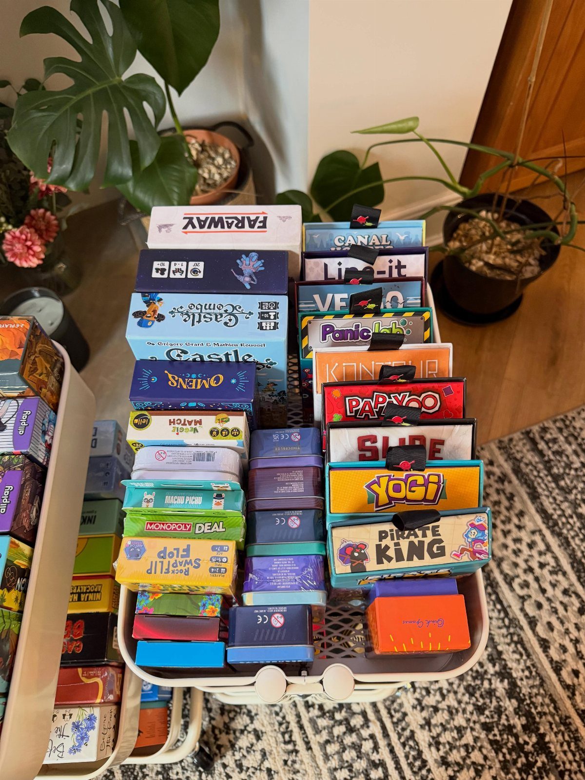 White basket filled with various colorful board game and card game boxes.