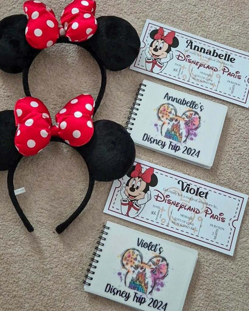 Minnie Mouse headbands, personalized Disneyland Paris tickets, and trip notebooks on a carpet.