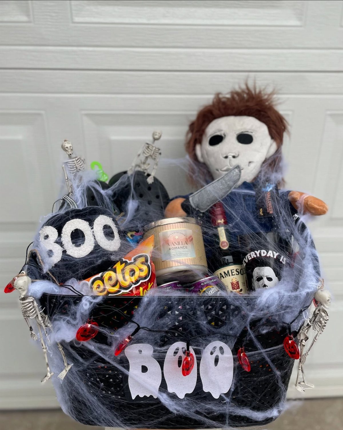Halloween gift basket with Michael Myers plush, snacks, and spooky spiderweb decorations.