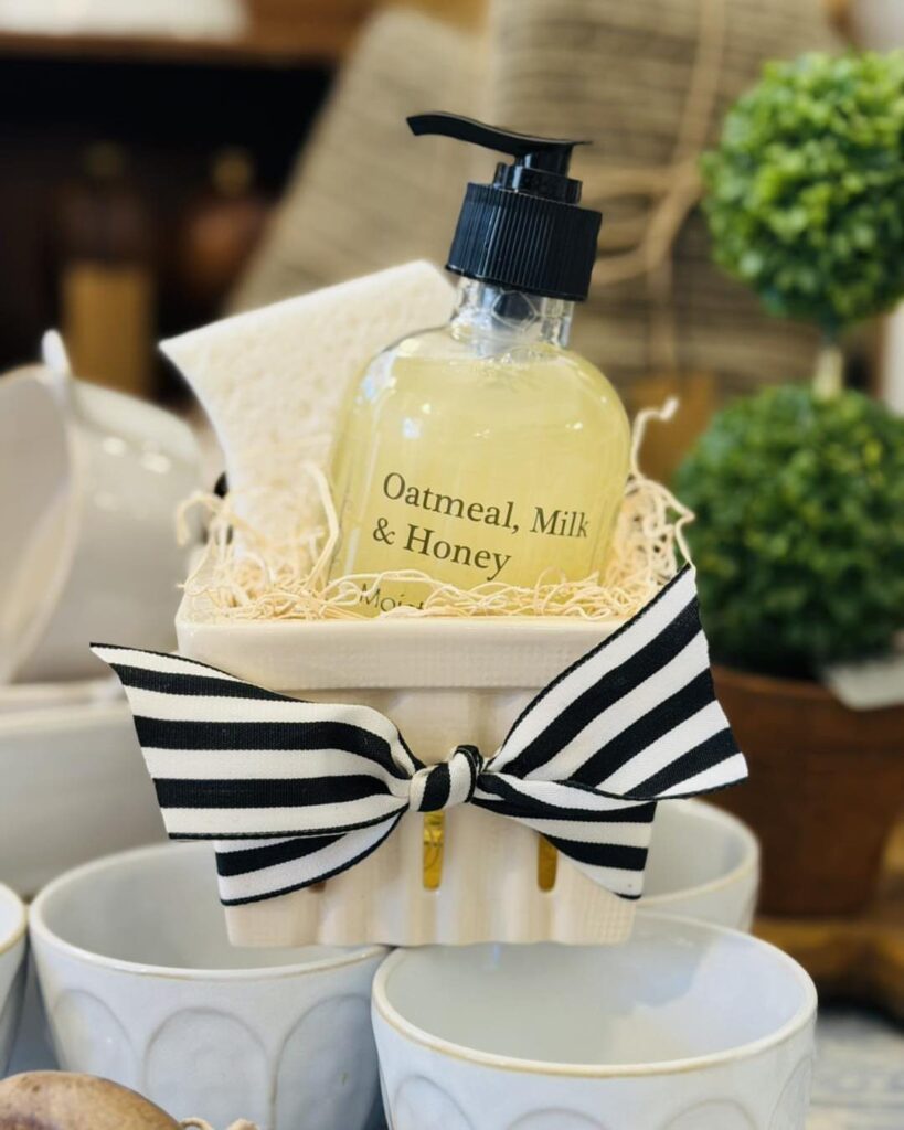 Scented hand soap and sponge in a white crate with a striped bow.