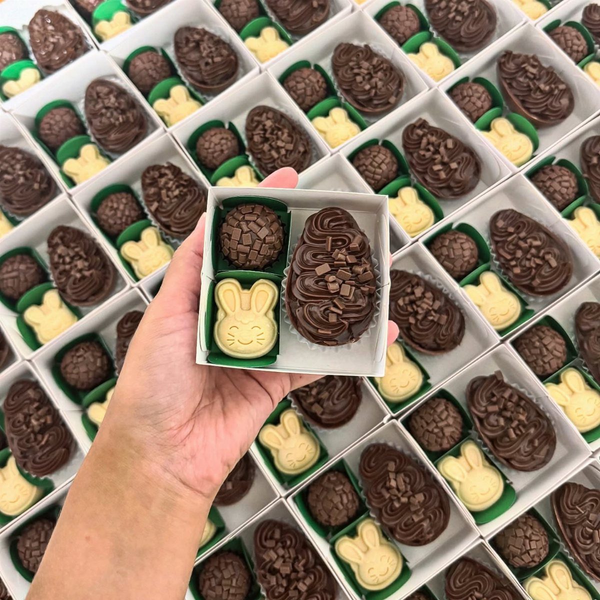 Hand holding a small box of bunny and egg shaped chocolates