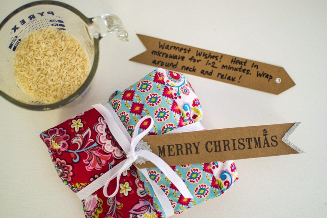 Colorful fabric heating pads with rice in a measuring cup and gift tags.